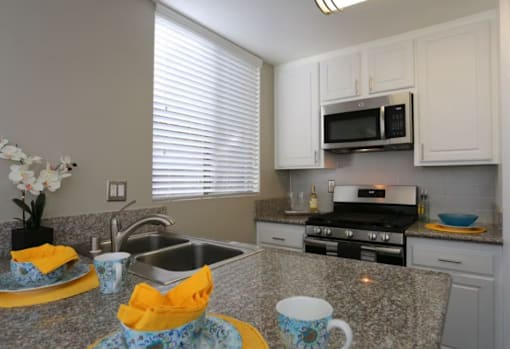 A kitchen with granite countertops and a stainless steel sink.