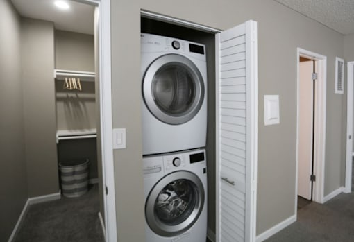 A white washing machine is in a small laundry room.