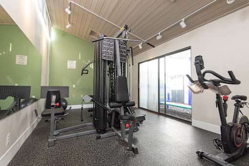 A gym with a treadmill, elliptical trainer and a stationary bike.