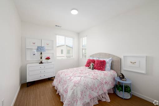 A bedroom with a bed, nightstand, and dresser.