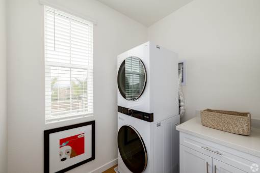 A white front loading washing machine in a laundry room.