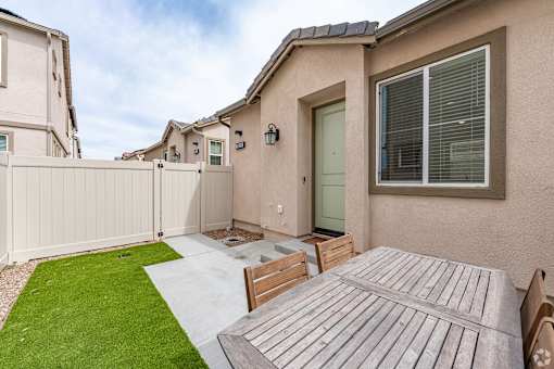 A house with a green lawn and a wooden deck.