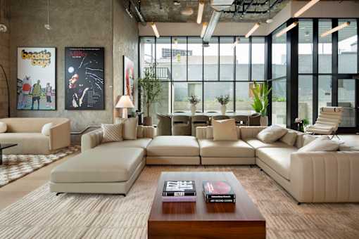 A modern living room with a large window and a variety of seating options.