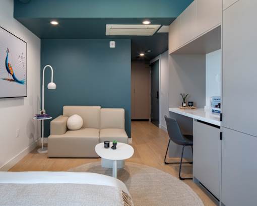 A living room with a grey couch, a white coffee table, and a grey chair.