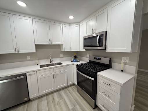A kitchen with white cabinets and stainless steel appliances.
