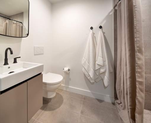 A bathroom with a toilet, sink, and towel rack.