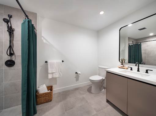 A bathroom with a white toilet, a sink, and a shower.