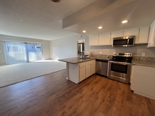 an empty kitchen with stainless steel appliances and a counter top