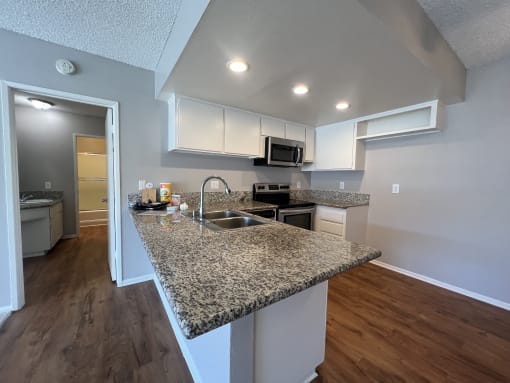 an open kitchen with granite counter tops and a sink
