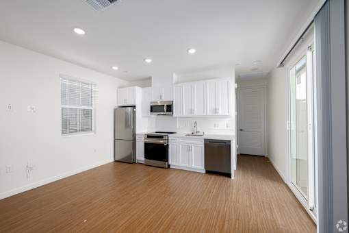 A modern kitchen with white cabinets and stainless steel appliances.