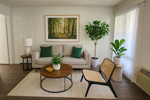A living room with a couch, chair, and potted plants.