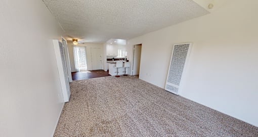 A room with a carpeted floor and a white wall.