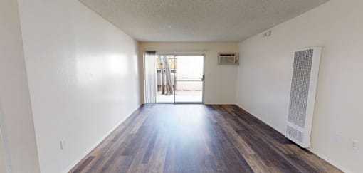 A room with a sliding glass door leading to a balcony.