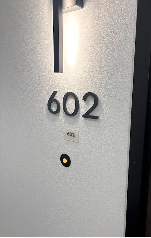 A white door with a black handle and a number 602 on it.