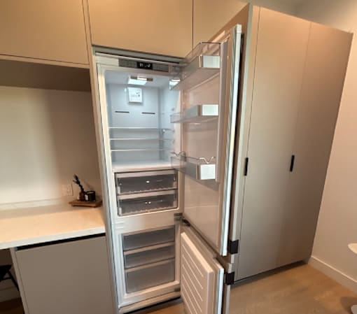 A white refrigerator with its door open in a kitchen.