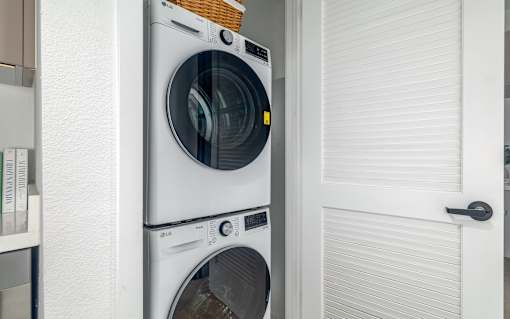 Two washing machines stacked on top of each other in a laundry room.