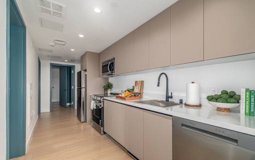 A modern kitchen with a refrigerator, oven, and sink.
