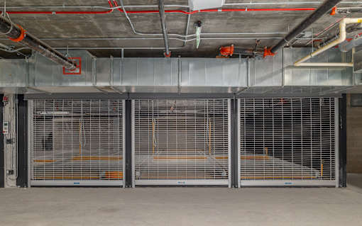 A large, empty industrial space with metal grates on the doors.