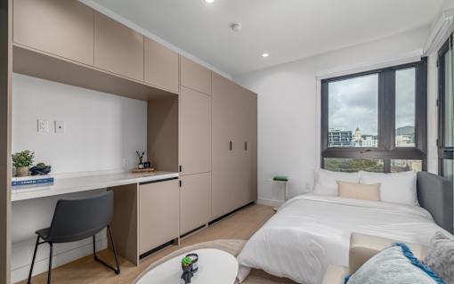 A bedroom with a bed, desk, and chair.