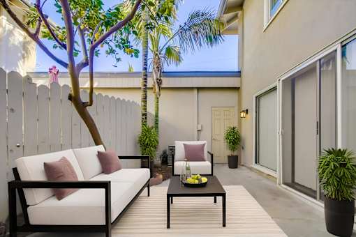 A patio with a white couch and a black table.