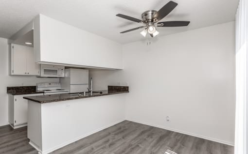 an open kitchen and living room with a ceiling fan