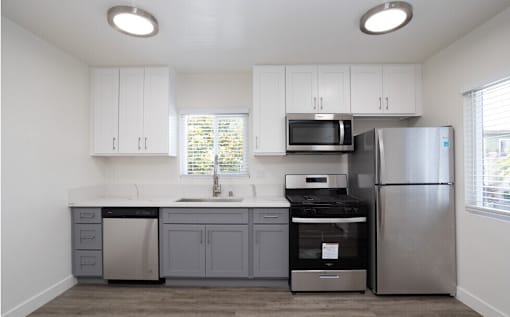 A kitchen with white cabinets and stainless steel appliances.