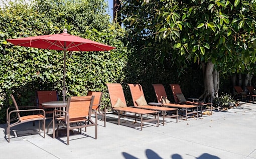 A row of chairs and a table are set up on a patio.