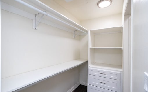 A white closet with a shelf and drawers.