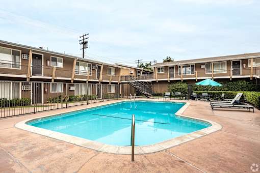 A swimming pool in front of apartment buildings.