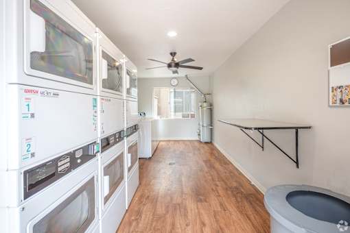A laundry room with a washer and dryer on the left and a toilet on the right.