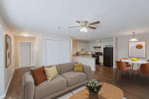 A living room with a grey couch and a brown pillow.