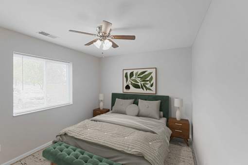 A bedroom with a bed, nightstands, and a ceiling fan.