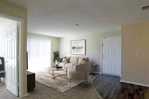 A living room with a couch, chair, and rug.