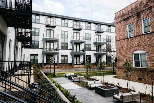 A courtyard with a black railing and a brick building. at The Quarter Lofts Apartments, Jackson, MS, 39216