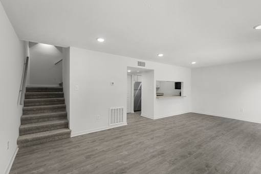 A room with a staircase and a refrigerator.