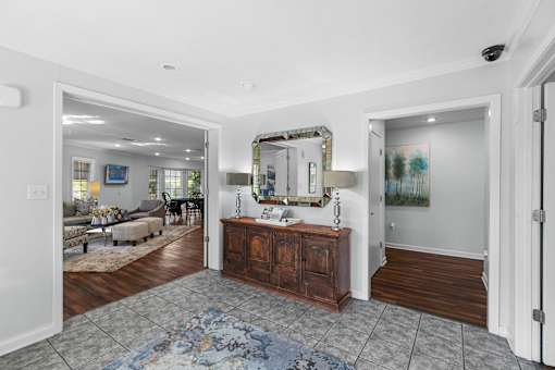 A large room with a wooden floor and a rug in the middle.