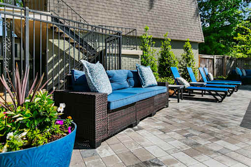 A patio with a couch and chairs.