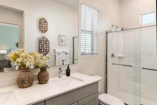 Bathrooms with dual sinks, wood plank floors, walk-in showers  at Pillar at Fountain Hills