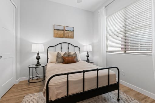 a bedroom with a bed and a large window at Village of Chandler Apartments, Chandler, AZ