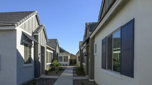 a row of houses with walkways between them and a blue sky at Village of Chandler Apartments, Chandler, Arizona
