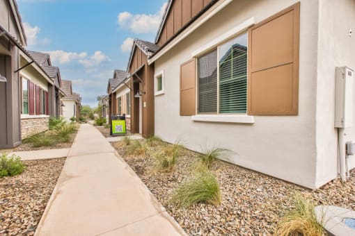 a row of houses with a sidewalk in front of them at Village of Chandler Apartments, Chandler, AZ