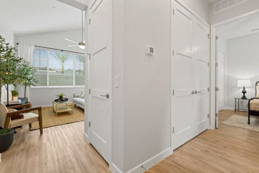 an open living room and dining room with white walls and wood floors at Village of Chandler Apartments, Arizona