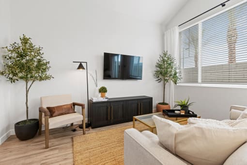 a living room with a couch and a tv on the wall at Village of Chandler Apartments, Chandler, AZ, 85249