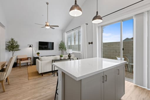 a kitchen island in a living room with a couch and a tv at Village of Chandler Apartments, Arizona, 85249
