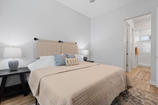 a bedroom with a large bed and a door to a bathroom at Village of Chandler Apartments, Chandler, 85249