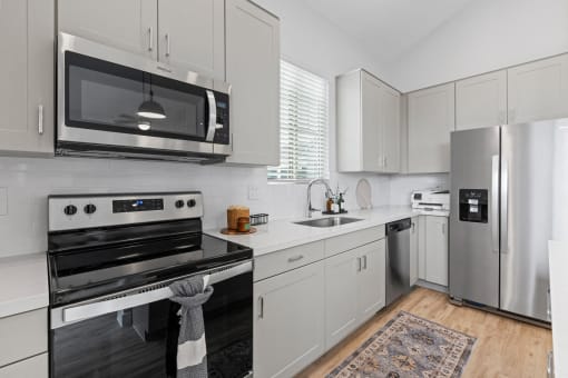 a kitchen with stainless steel appliances and white cabinets at Village of Chandler Apartments, Chandler, 85249