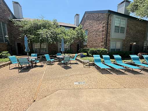 A sunny day at the pool with chairs and umbrellas.