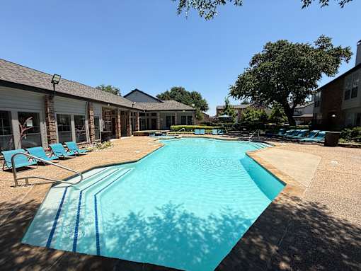 A large swimming pool in a sunny outdoor setting.