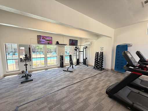 A gym with treadmills, exercise bikes, and other equipment.