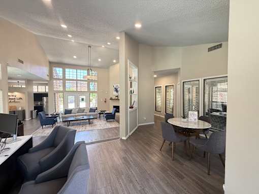 A spacious waiting room with grey chairs and a white table.